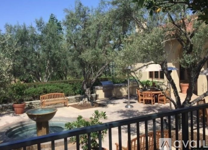 A patio with a table and chairs overlooks a garden.