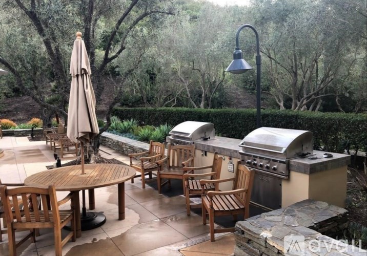 A patio with a table, chairs, and an umbrella.