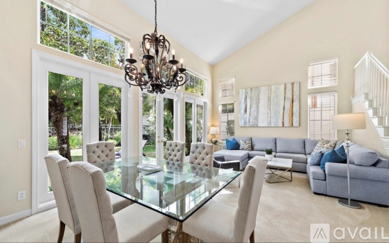 A modern dining room with a glass table and chairs.
