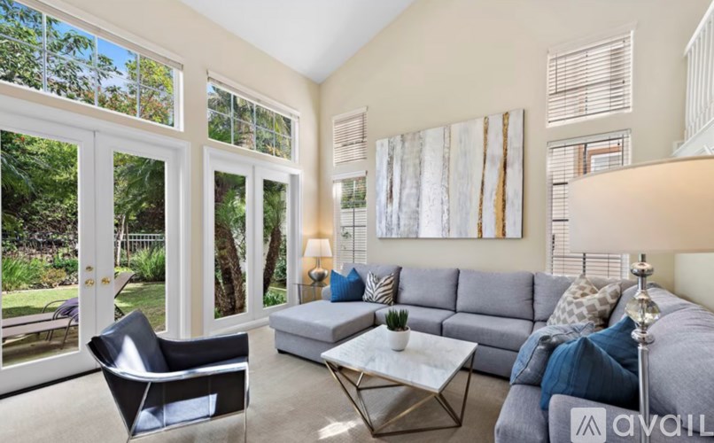 A living room with a grey couch, a black chair, and a coffee table.