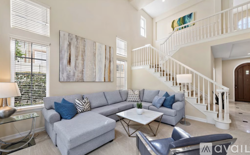 A living room with a grey couch and a white coffee table.