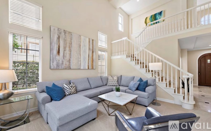A living room with a grey couch and a white coffee table.