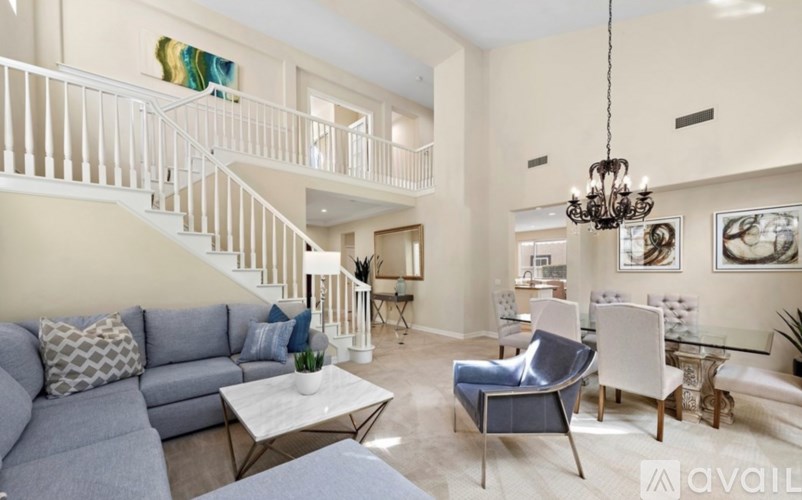 A living room with a grey couch and a white chair.