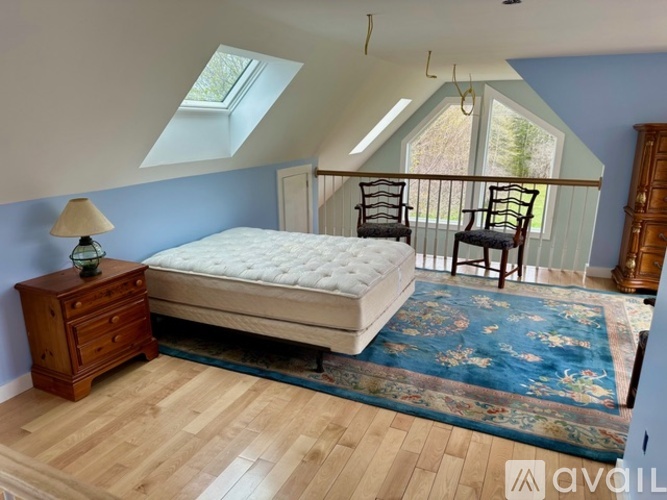 A bedroom with a bed, a dresser, and a window.
