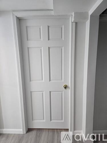 A room with a door, window, and carpeted floor.