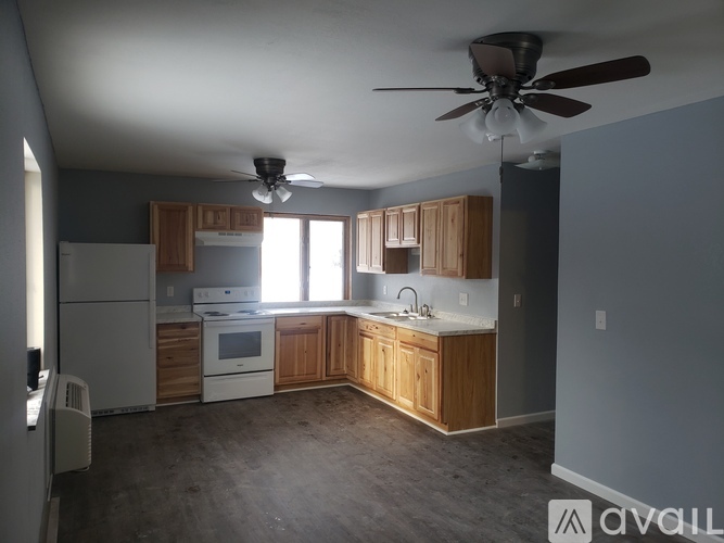 A kitchen with wooden cabinets and a white fridge.
