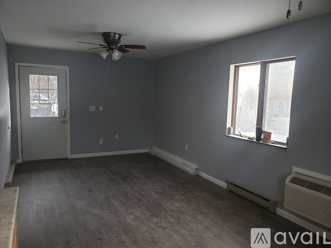 A room with a ceiling fan and a window.