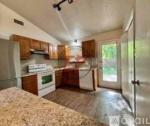 A kitchen with wooden cabinets and a white stove top oven.