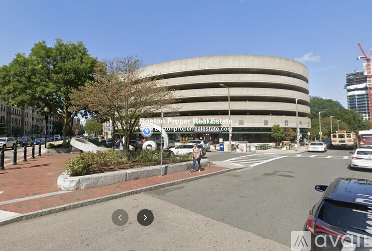 A street view of a round building with a sign that says Boston Property Real Estate.