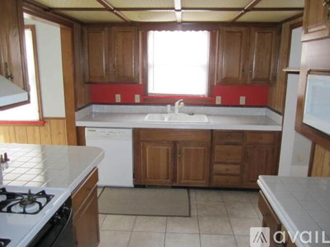 A kitchen with wooden cabinets and a white stove top oven.