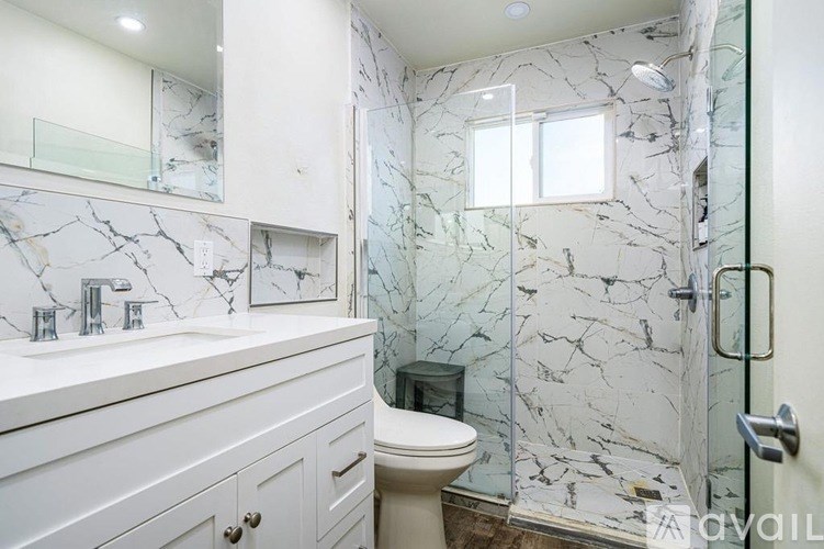 A bathroom with a marble wallpaper and a toilet.