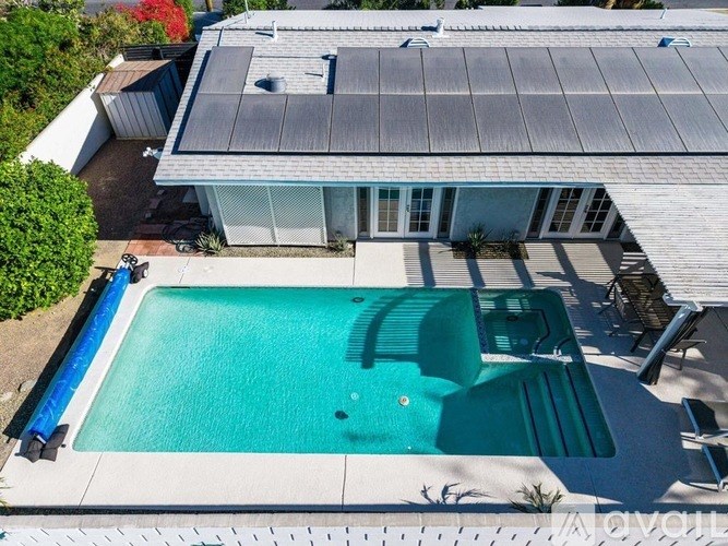 A swimming pool in a backyard with a house in the background.