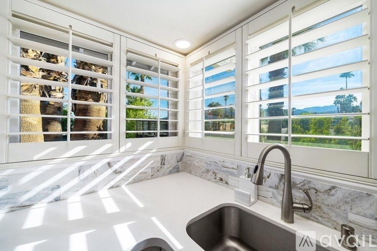 A kitchen with a marble countertop and a sink.