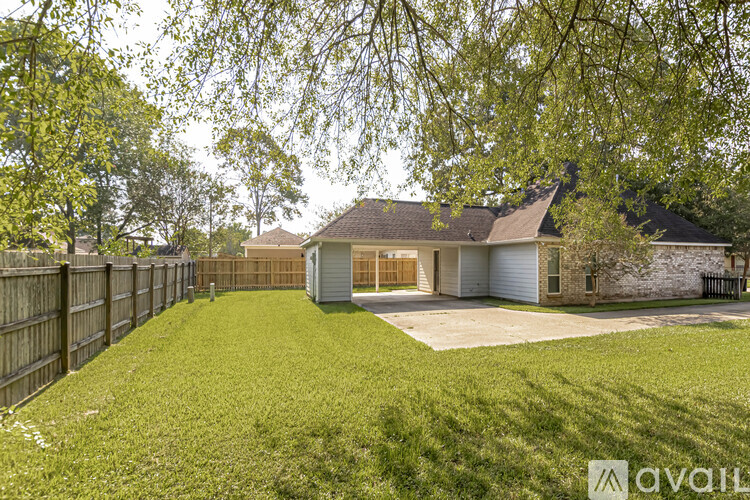 A house with a fence and green grass in front.