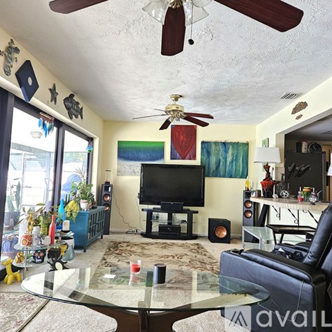 A living room with a television and a glass table.
