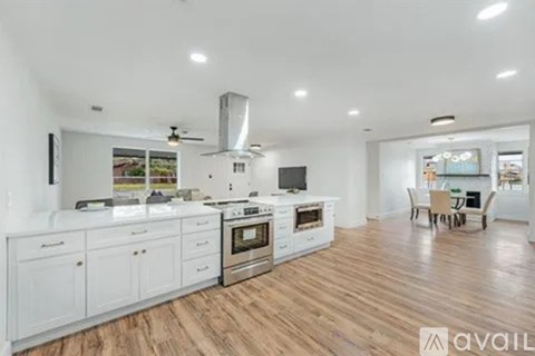 A modern kitchen with white cabinets and stainless steel appliances.