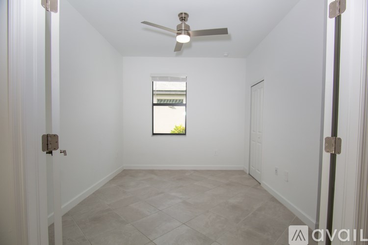 A spacious room with white walls and a tiled floor.