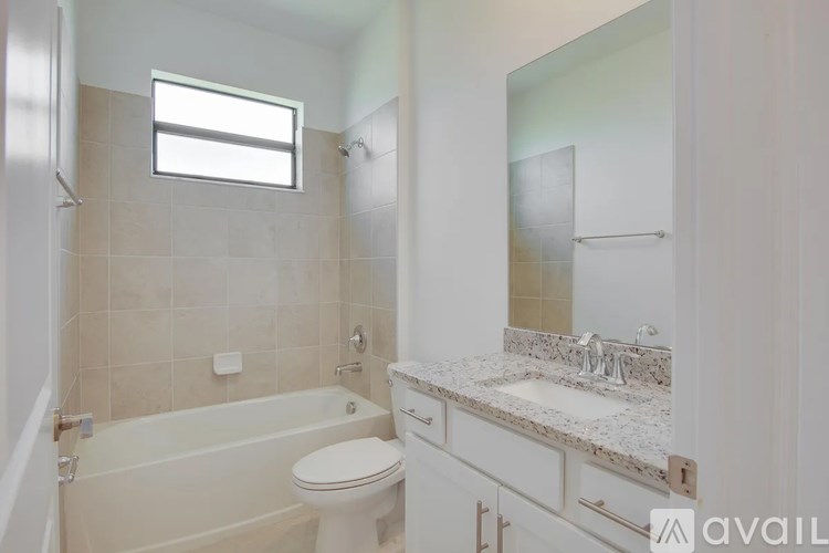 A bathroom with a tub, toilet, and sink.