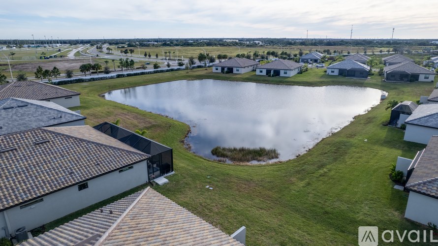 A bird's eye view of a residential area with a lake in the foreground.