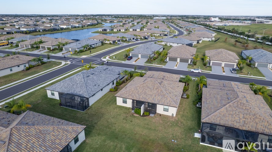 A bird's eye view of a suburban neighborhood with houses and a roundabout.