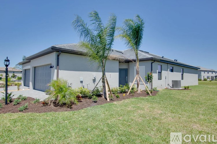 A house with a well-maintained lawn and a few trees in front.