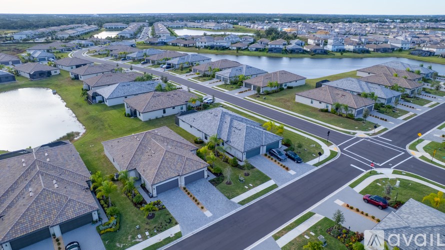 A bird's eye view of a residential area with houses, roads, and a body of water.