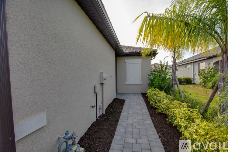 A house with a white wall and a small garden in front.