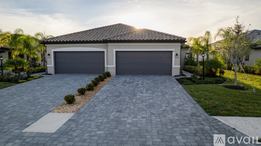 A house with a driveway and garage doors.