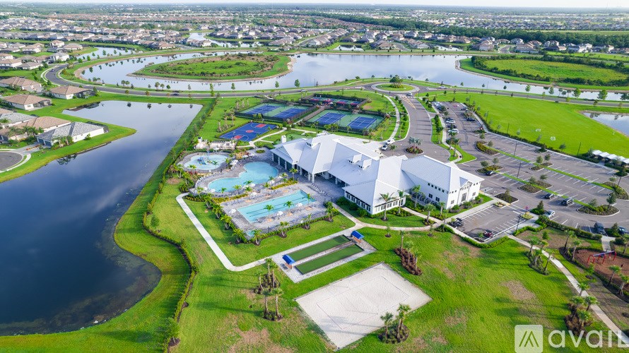 An aerial view of a resort with a swimming pool and a river.