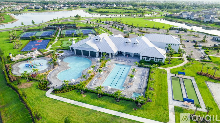 An aerial view of a resort with a swimming pool and a large building.