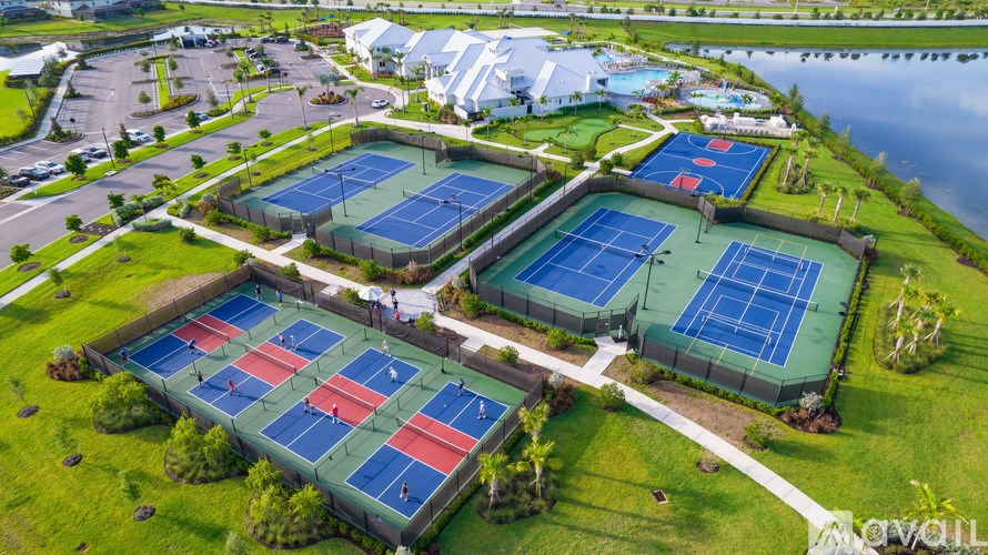 An aerial view of a tennis court surrounded by a fence.