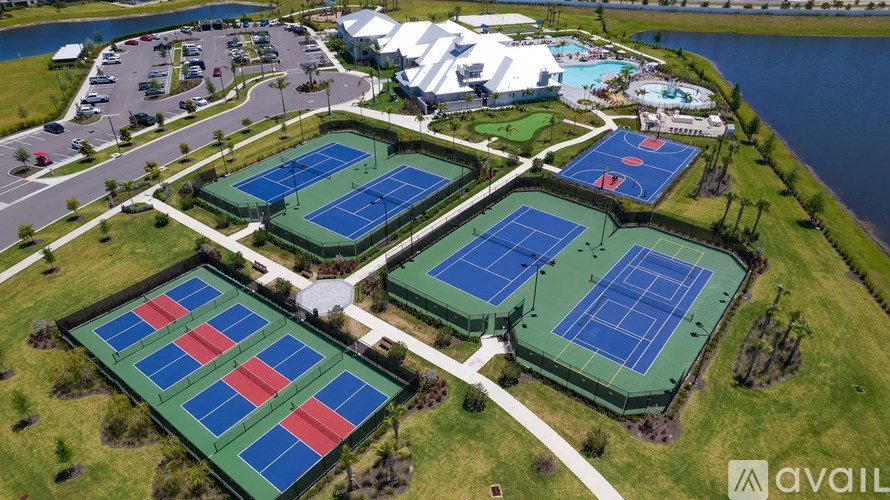 A tennis court complex with multiple courts and a parking lot.