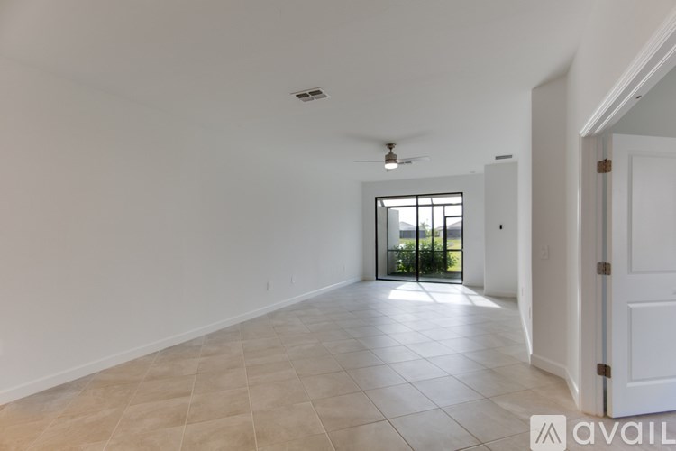 A large open garage with a blue trash can and a white wall.