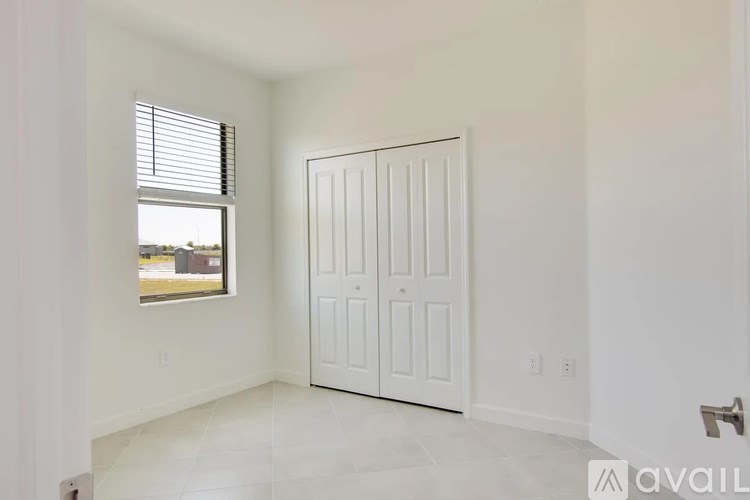 A white door is in a room with a window.