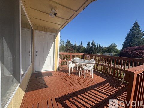 A patio with a table and chairs overlooking a forest.