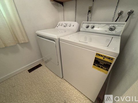 A white dryer and washer are in a small laundry room.