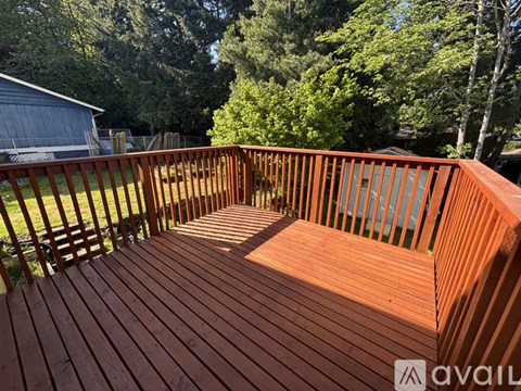 A wooden deck with a railing and a backyard.
