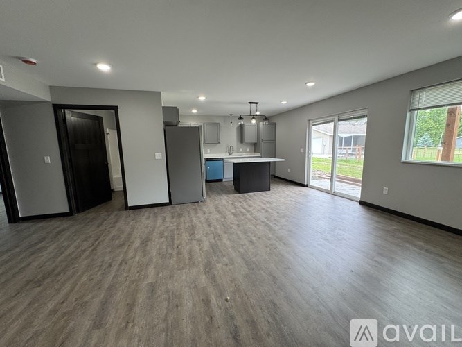 A spacious room with a kitchenette and a refrigerator.