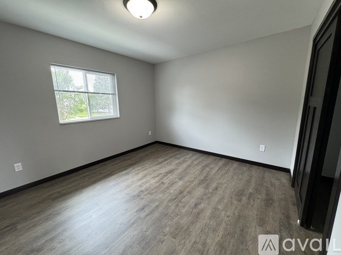 A room with a window and wooden flooring.