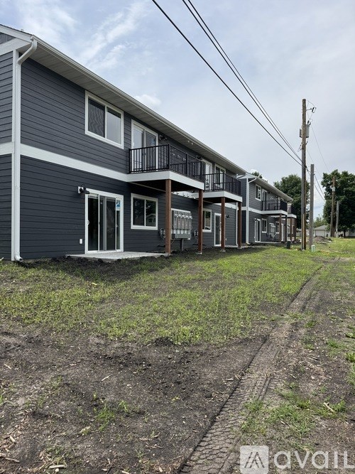 A row of houses with a dirt road in front.