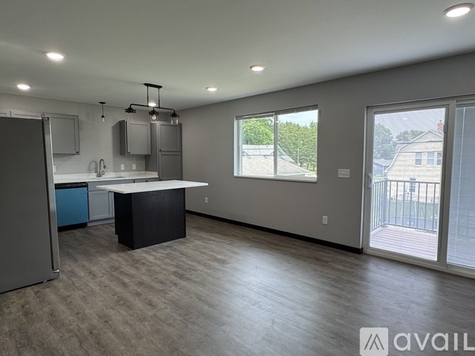 A spacious kitchen with a large island and a view of the backyard through the sliding glass doors.