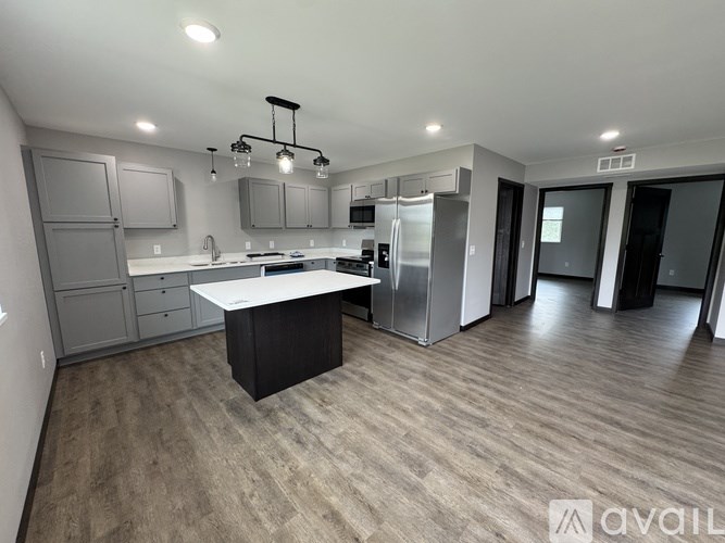 A grey two-story house with a black car parked in front.