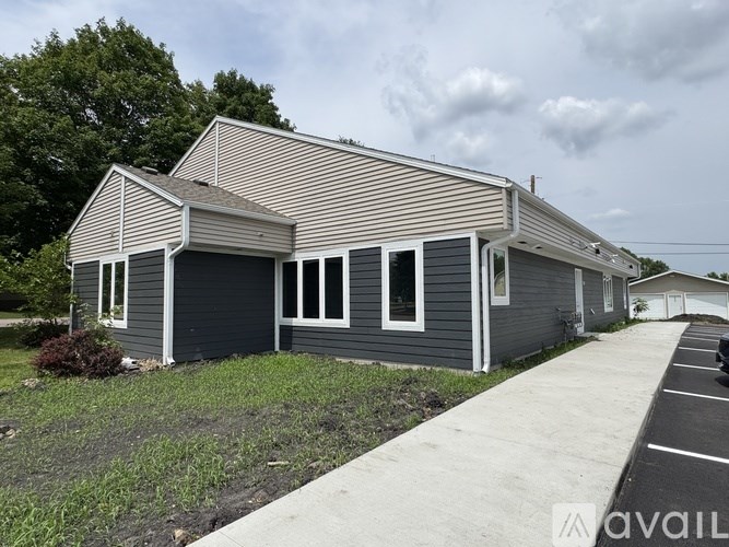 A house with a grey exterior and a striped roof is available for rent.