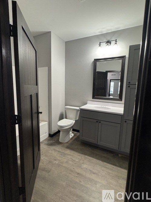 A bathroom with a toilet, sink, and mirror.