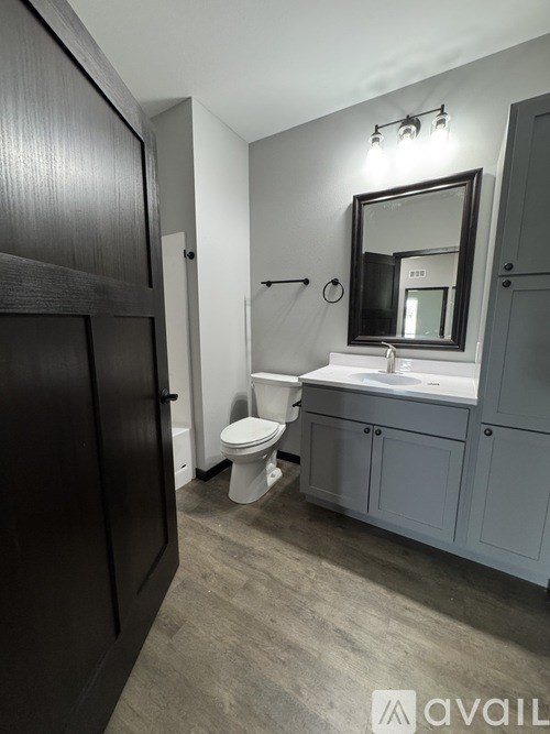 A bathroom with a toilet, sink, and mirror.
