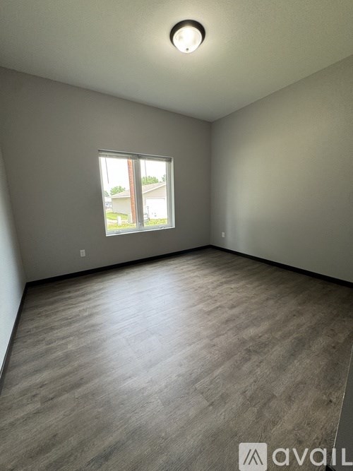 A room with a window and wooden flooring.