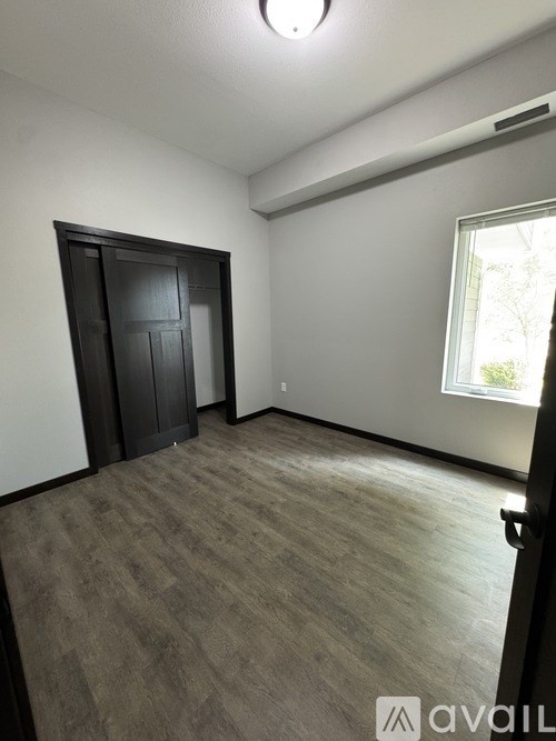 A room with a grey carpet and a black door.