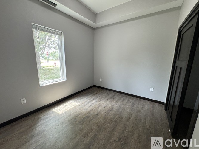 A room with a window and wooden flooring.