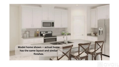 A kitchen with white cabinets and a model home layout.