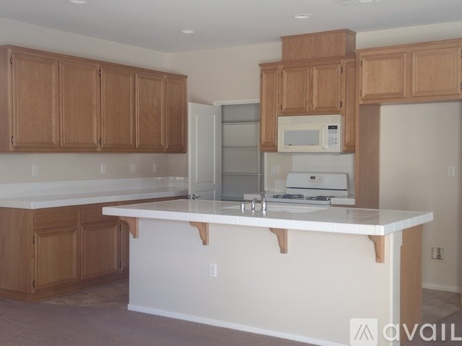 A kitchen with wooden cabinets and a white island.